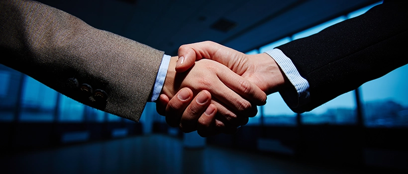 handshake symbolizing the Broadcom acquisition of VMware